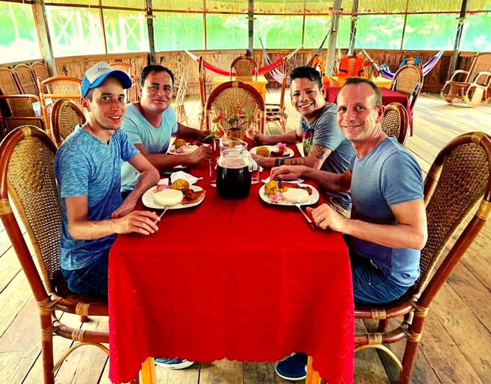 een groep mannen die aan een tafel eten bij Intillama Jungle Lodge EIRL in Paucarpata