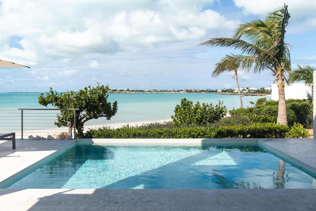 a swimming pool with a view of the beach at SulMare at Sapodilla Bay Luxury villas in Providenciales