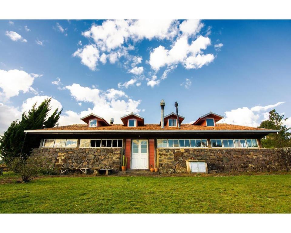 a large house with a stone wall at Fazenda Rodeio Bonito in Lages