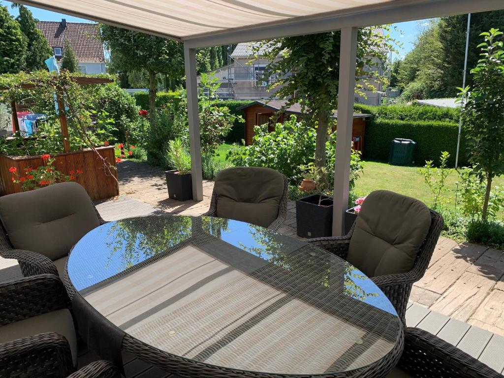 une table et des chaises en verre sur la terrasse dans l'établissement Adult only klimatisierte Ferienwohnung in Schwerte, à Schwerte