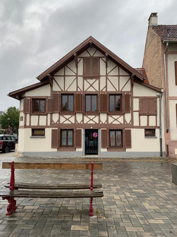 un banc en bois devant un bâtiment dans l'établissement La Casetta en ALSACE, à Schiltigheim