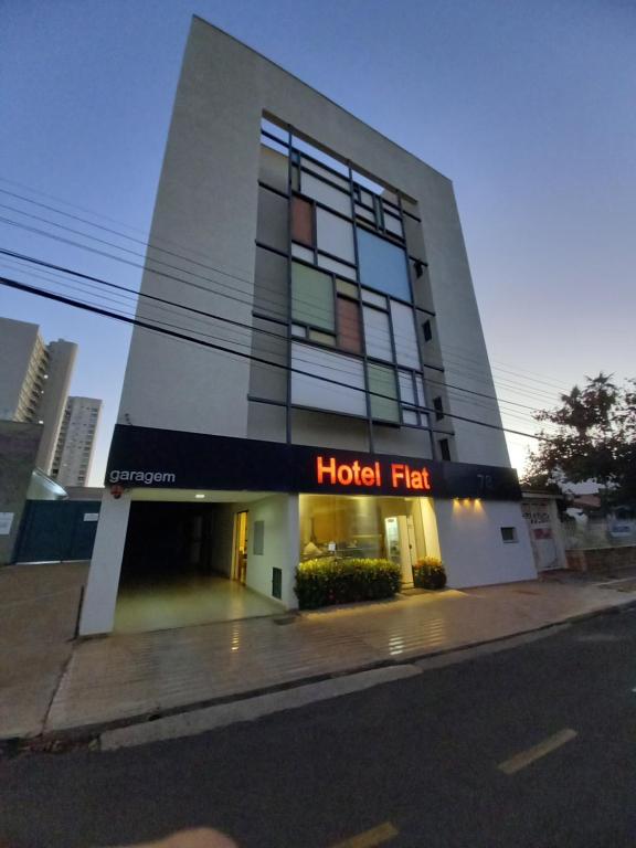 een hotelgebouw met een hotelbord op een straat bij Hotel Flat Alameda in Araçatuba