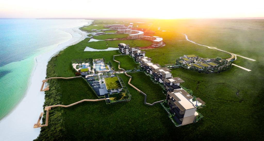 an aerial view of a resort on an island next to the ocean at Etéreo, Auberge Resorts Collection in Playa del Carmen