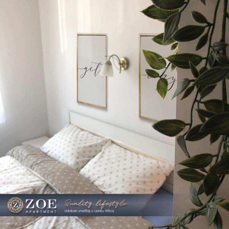 - un lit dans une chambre avec 2 photos sur le mur dans l'établissement ZOE apartment, à Vršac