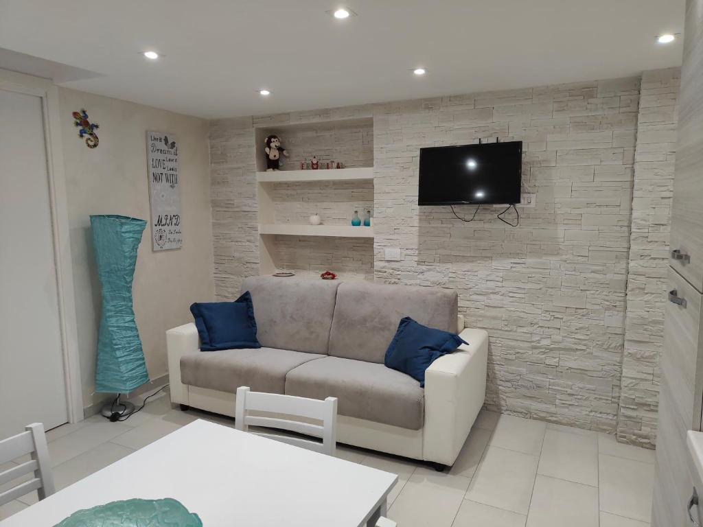 a living room with a couch and a tv on a brick wall at IL GECO in Naples