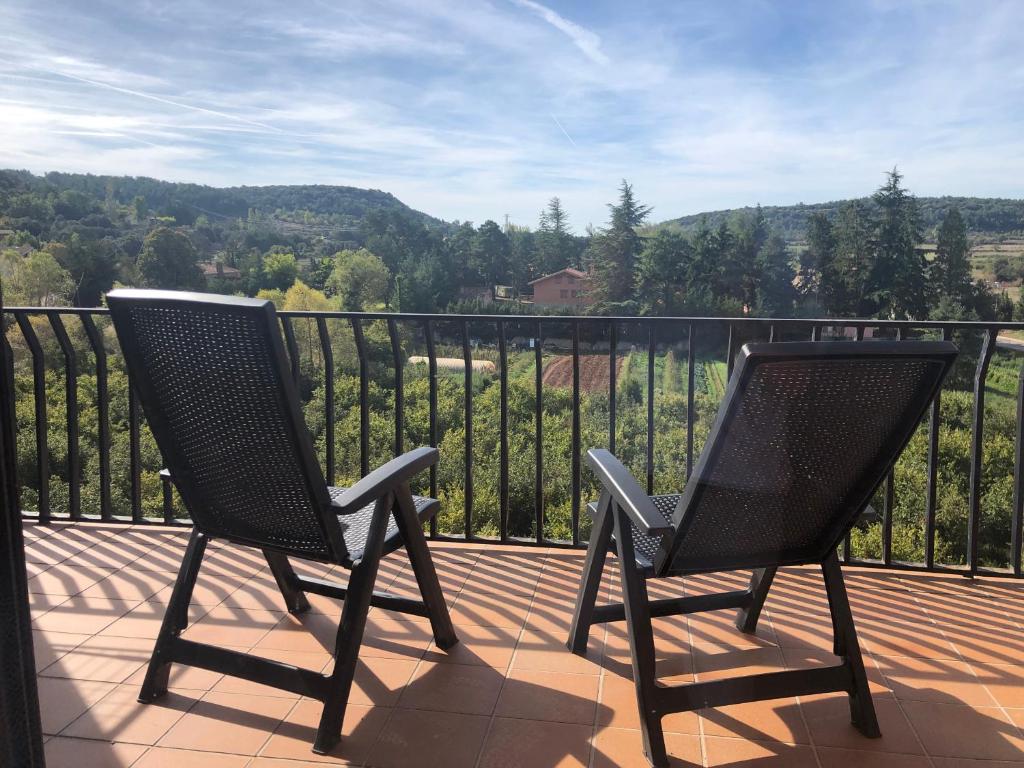 2 sillas sentadas en un balcón con vistas en EVA & TRAVEL - Triplex La Cavallada, en Prades
