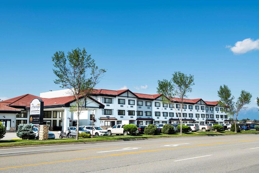 a large white hotel with cars parked in front of it at Prestige Rocky Mountain Resort Cranbrook, WorldHotels Crafted in Cranbrook