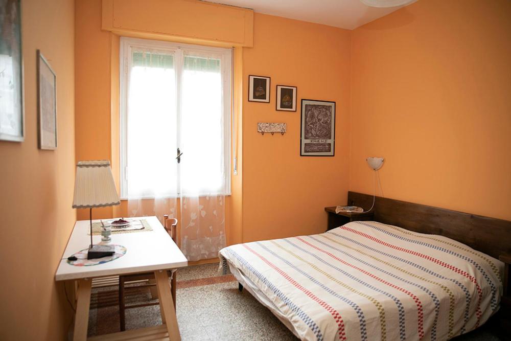 a bedroom with a bed and a desk and a window at Casa Abba-2 in Alessandria