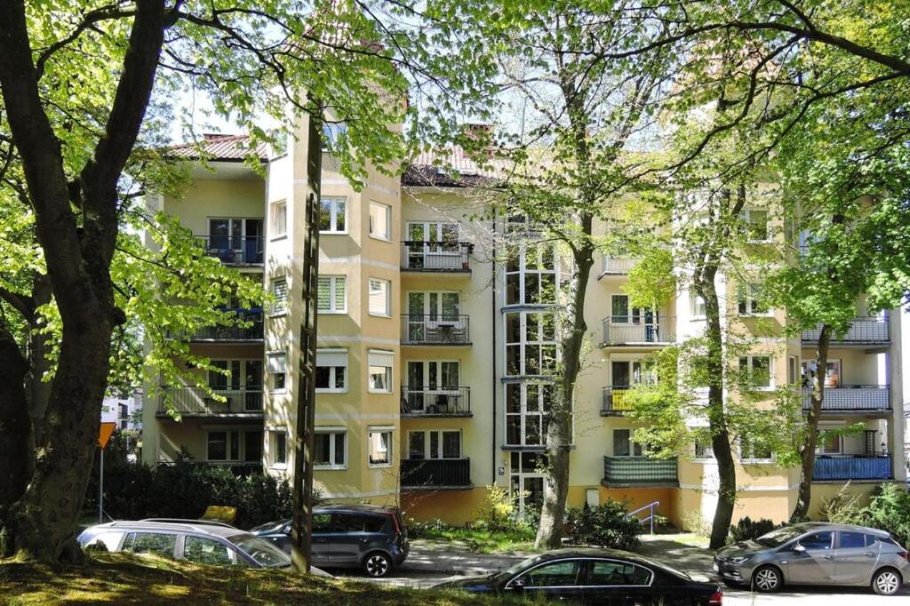 an apartment building with cars parked in front of it at Holiday flat, Miedzyzdroje in Międzyzdroje