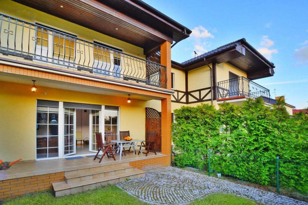 een huis met een balkon en een patio bij Terraced house, Grzybowo in Grzybowo