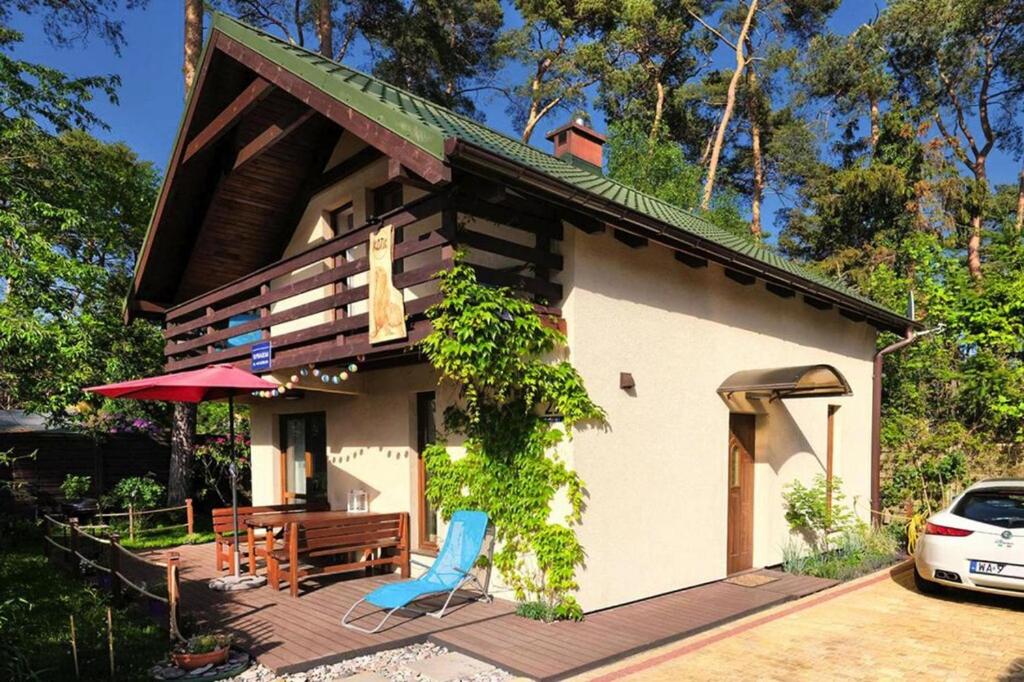 a house with a deck with a chair and a table at holiday home, Lukecin in Łukęcin