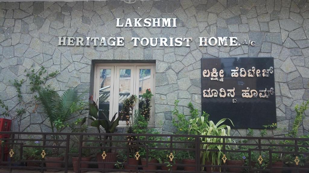 a building with a sign on the side of it at Lakshmi Heritage Tourist Home in Hampi