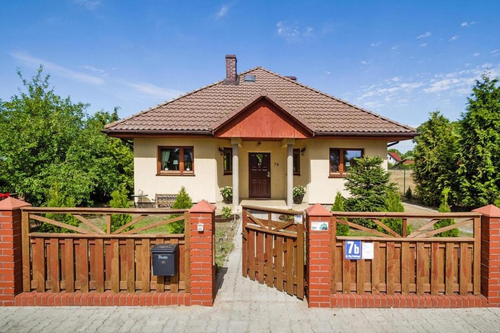 una casa con una valla de madera y una puerta en Holiday flat, Stepnica, en Stepnica