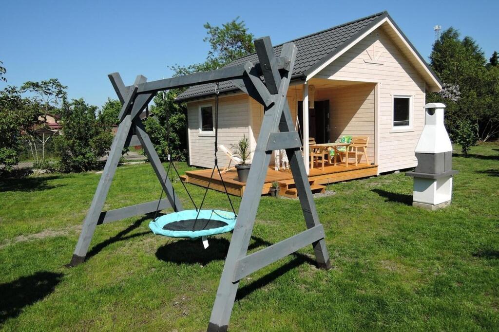 a swing set in front of a tiny house at holiday home, Kolczewo in Kołczewo