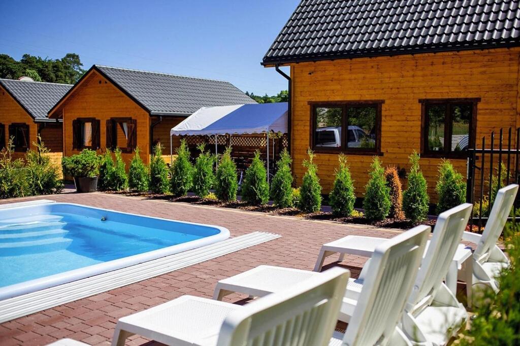 a backyard with a pool and chairs and a house at Holiday resort, Wiselka in Wisełka