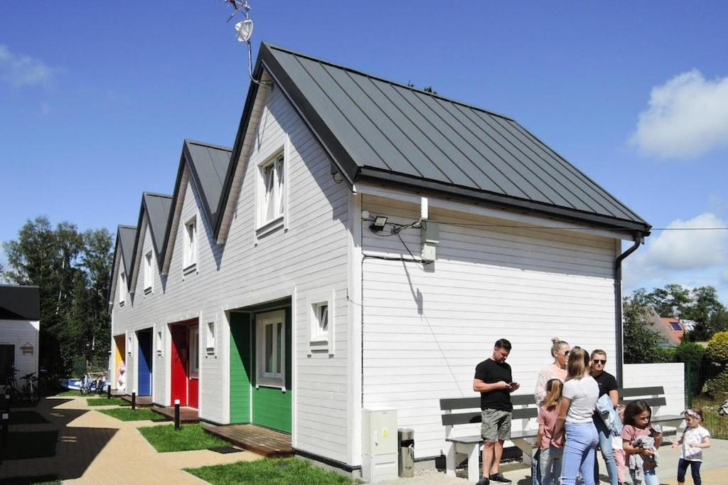 ジブヌフにあるApartment in Dziwnów by Baltic Sea Beachの小さな建物の前に立つ人々