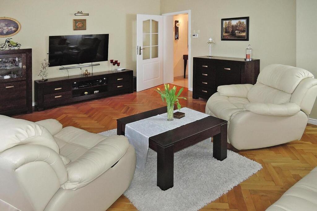 a living room with two white couches and a tv at Terraced house, Miedzyzdroje in Międzyzdroje