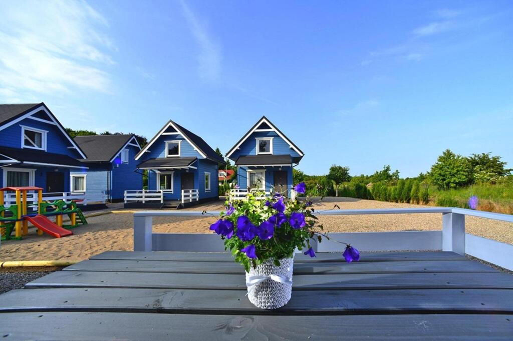 a vase of flowers sitting on a table with houses at Holiday homes, Rewal in Rewal