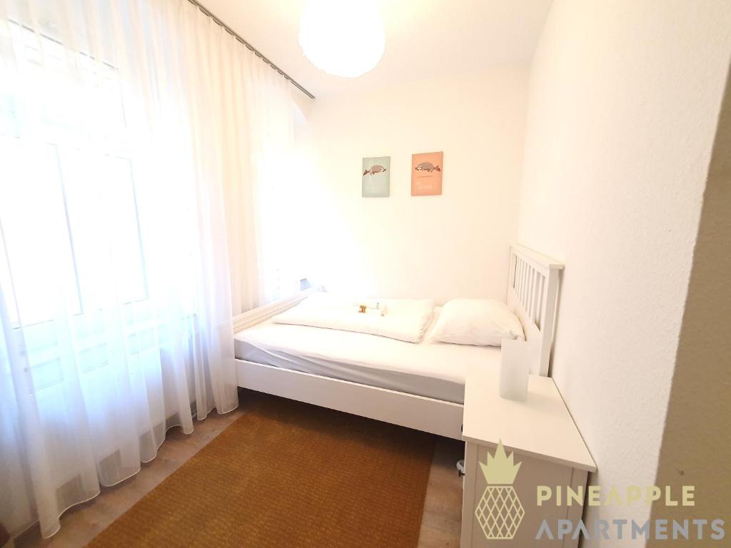 um quarto branco com uma cama e uma janela em Ruhiges Hinterhof Apartment im Herzen der Neustadt em Dresden
