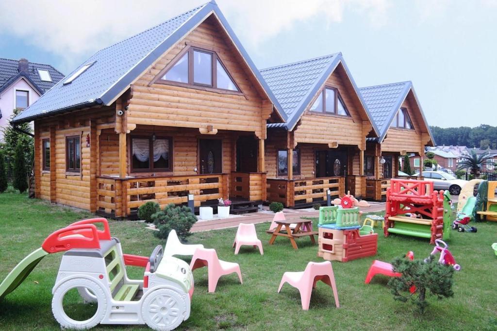 a log cabin with a lot of play equipment in front of it at Holiday homes, Rewal in Rewal