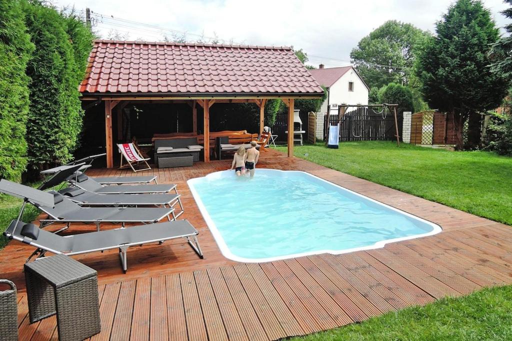 a large swimming pool with chairs and a gazebo at holiday home, Kolczewo in Kołczewo