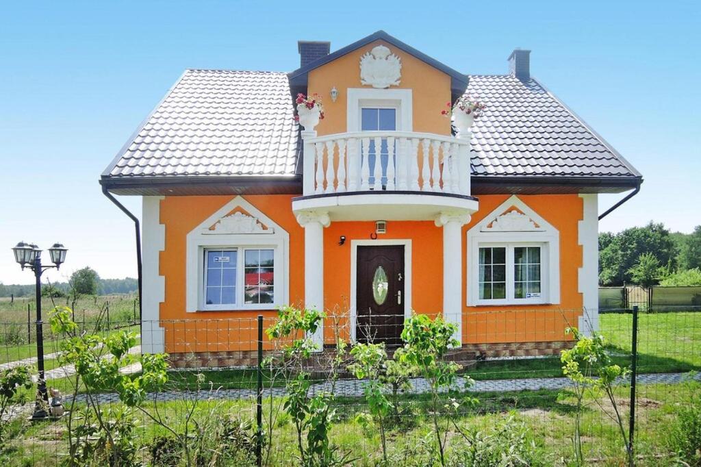 a small orange house with a balcony at holiday home, Nowe Warpno in Nowe Warpno