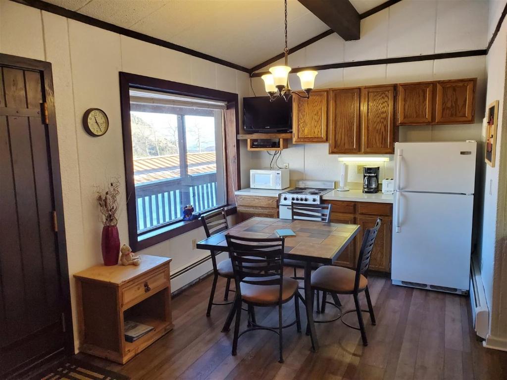 una cucina con tavolo, sedie e frigorifero di Brettelberg Slopeside Condos C4 a Carbondale
