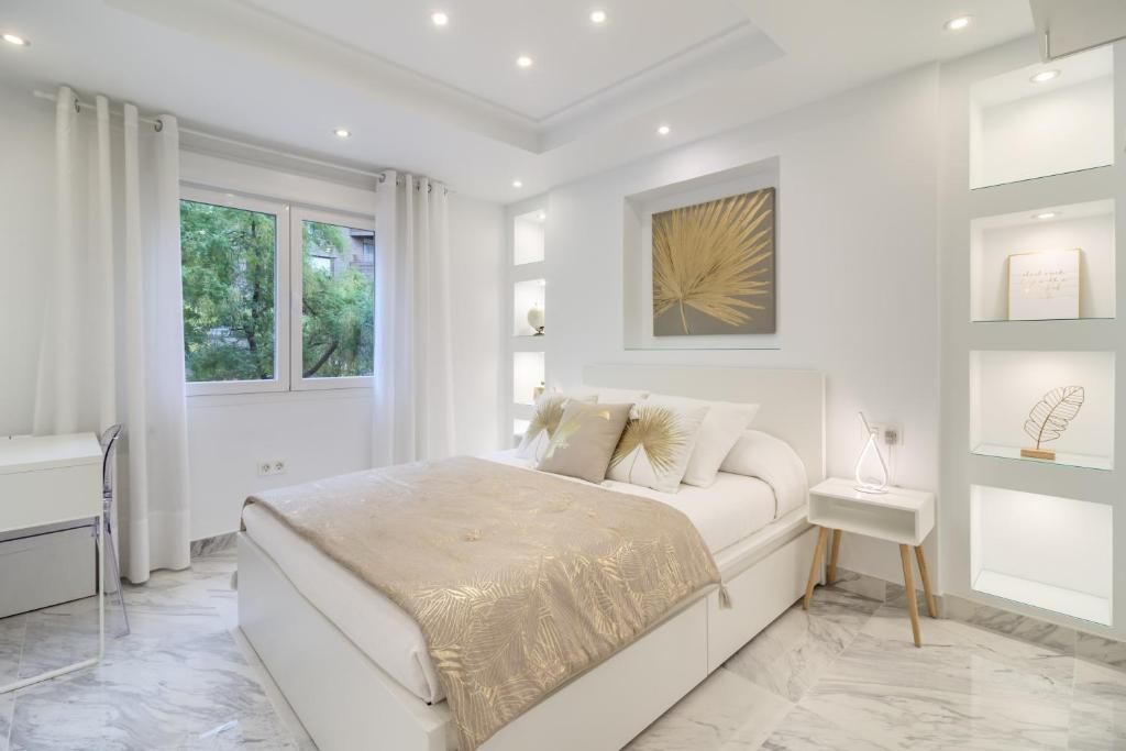 ein weißes Schlafzimmer mit einem Bett und einem Fenster in der Unterkunft PLAZA MENORCA in Granada