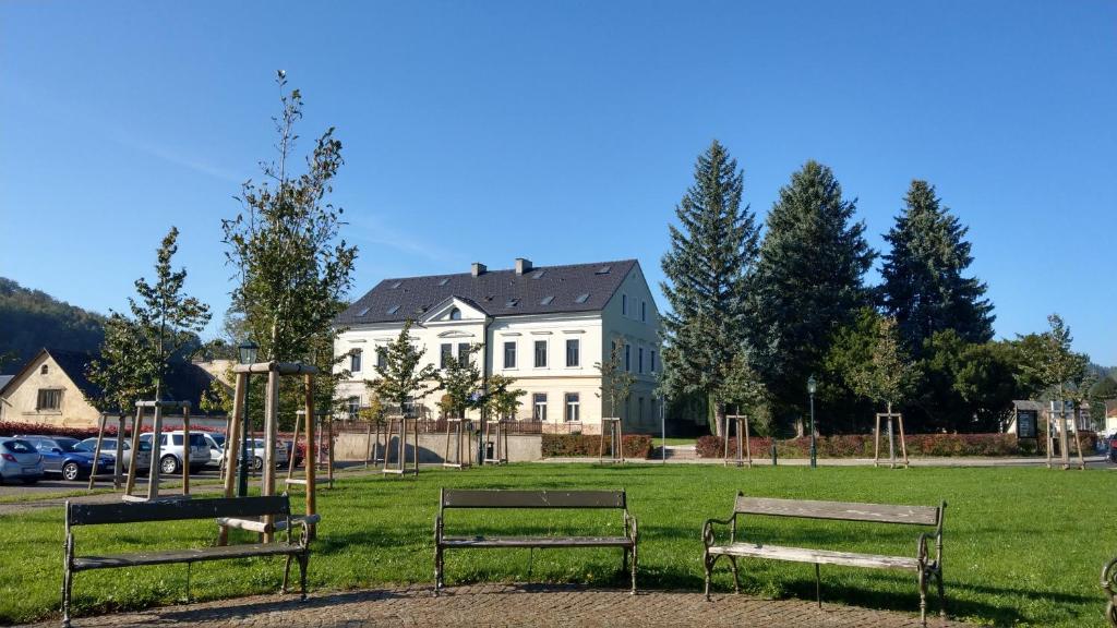 dwie ławki w parku przed domem w obiekcie Apartmány Klášterní 84 w mieście Hejnice