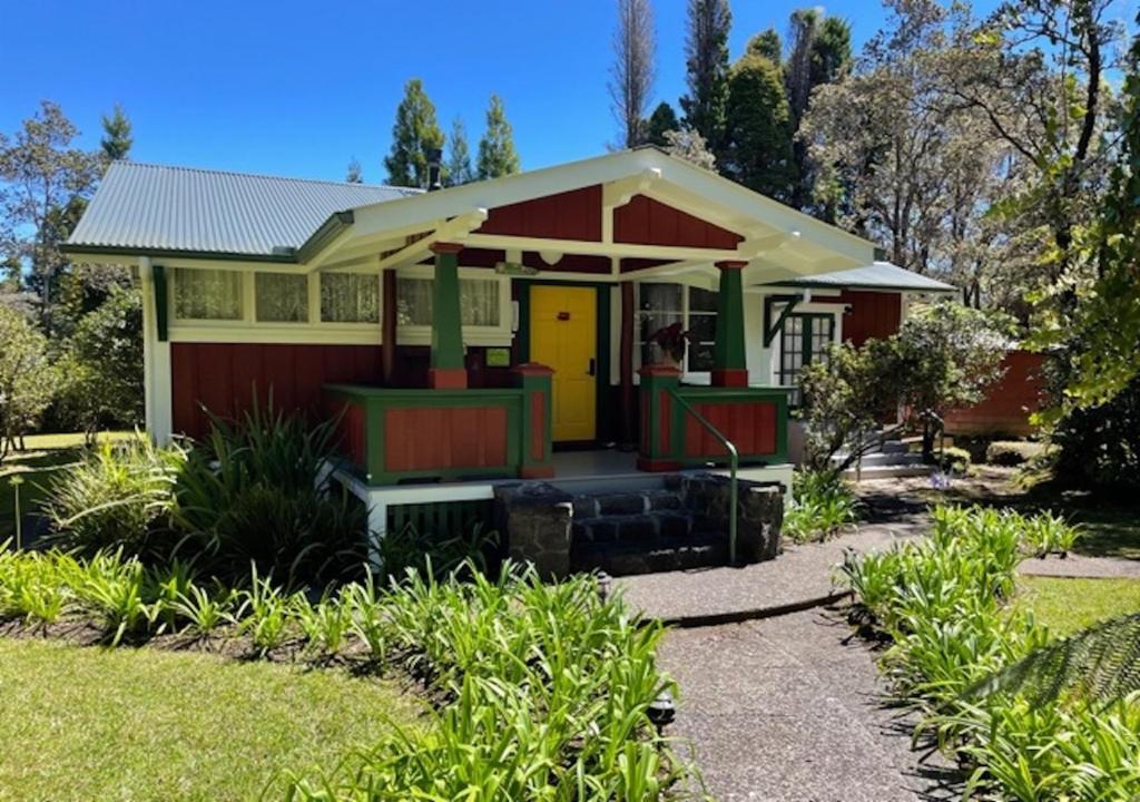 a small red and yellow house with a yellow door at Volcano Teapot Cottage in Volcano