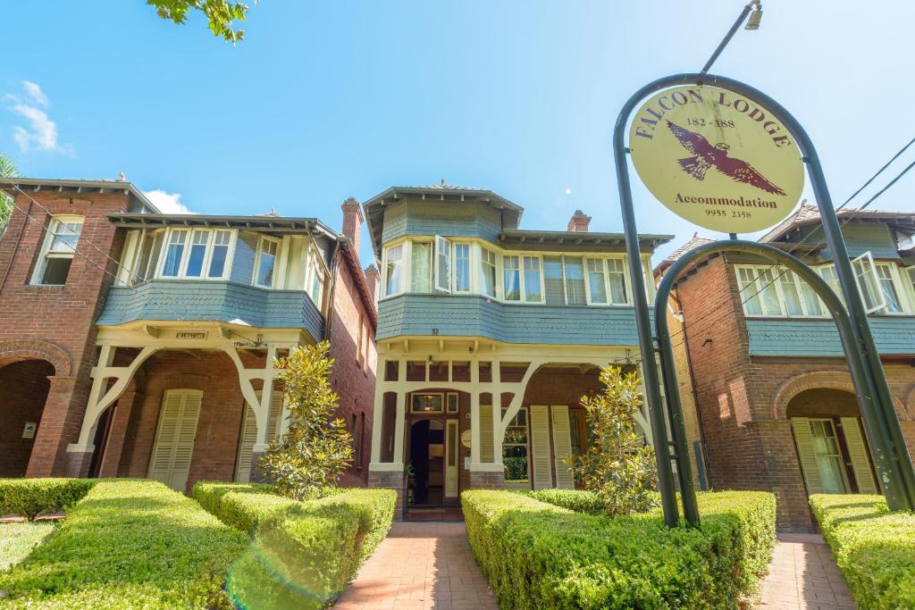 ein großes Haus mit einer Uhr davor in der Unterkunft Falcon Lodge in Sydney