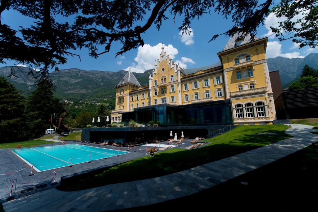 un grande edificio con piscina di fronte di Grand Hotel Billia a Saint Vincent