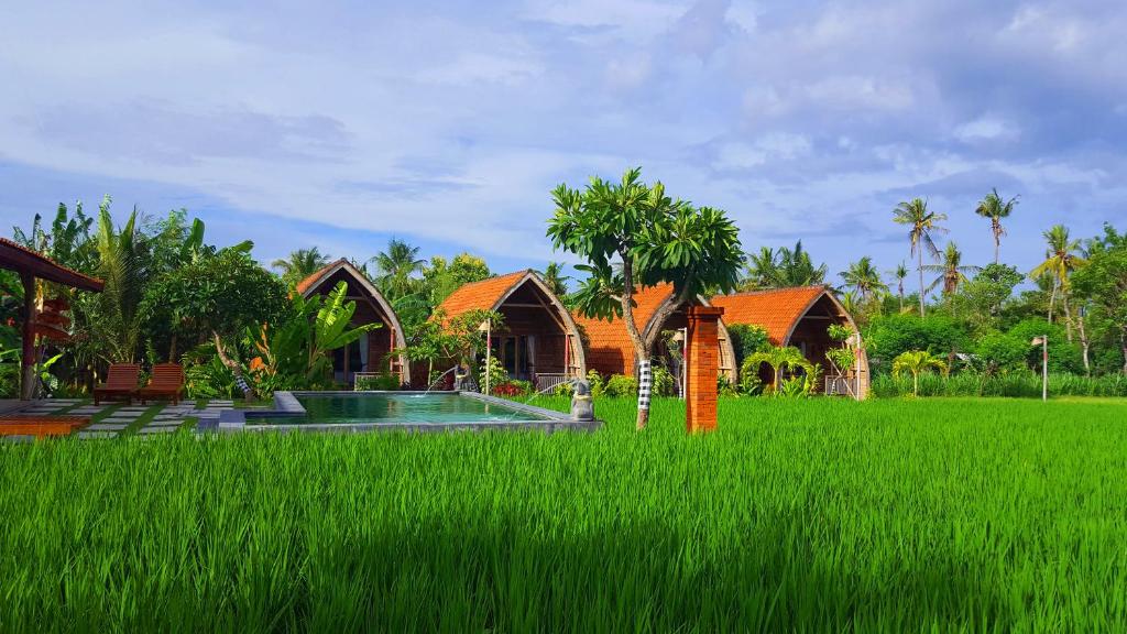 a villa in the middle of a field of grass at Umma Bali Menjangan Retreat in Banyuwedang