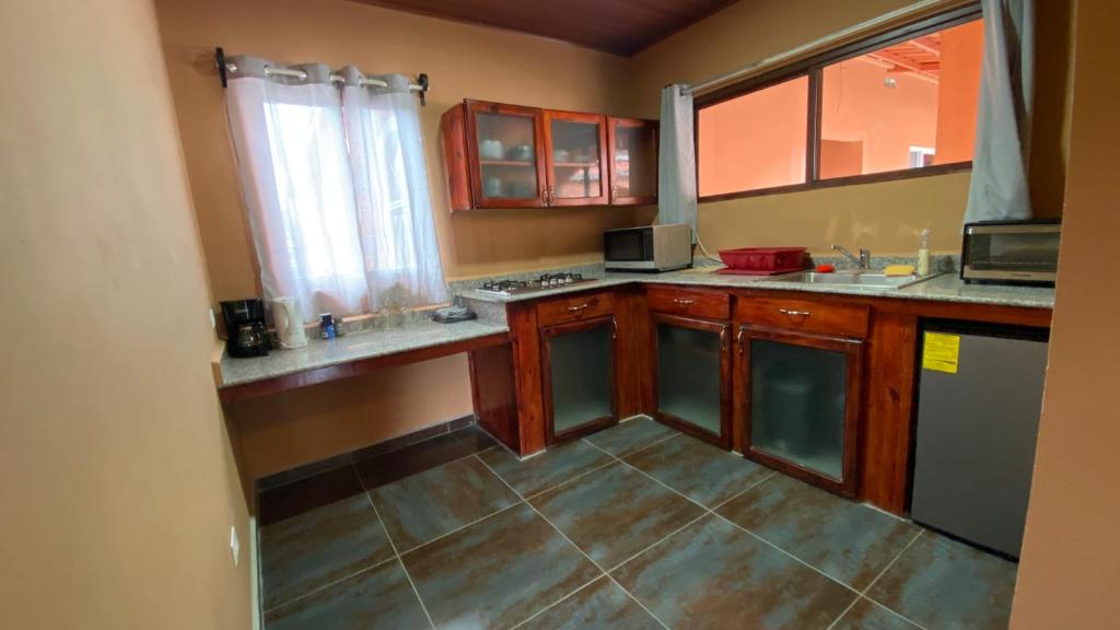 a kitchen with wooden cabinets and a tile floor at La Serrania B&B in Boquete