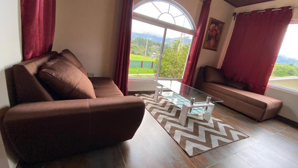 a living room with a couch and a glass table at La Serrania B&B in Boquete