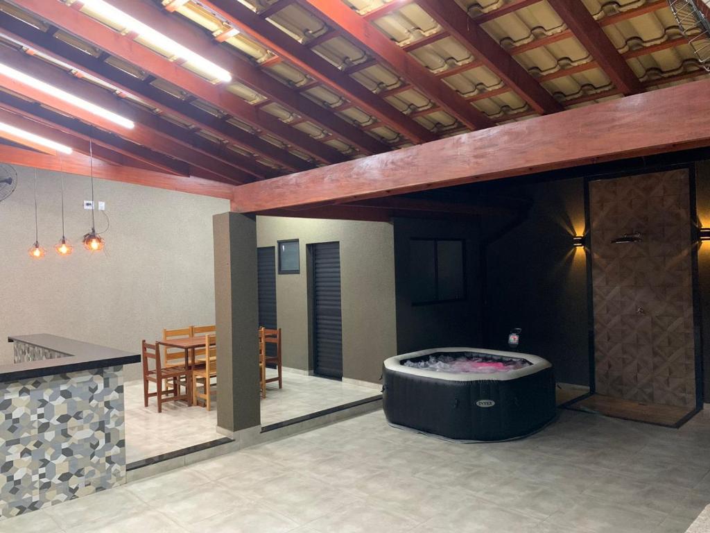 een woonkamer met een hot tub en een tafel bij Casa de Temporada Dona Santa in Olímpia