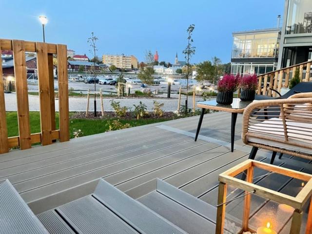 a wooden deck with two benches and a table at Lomavuokra Hanko, Laituri B4, Itäsatama in Hanko
