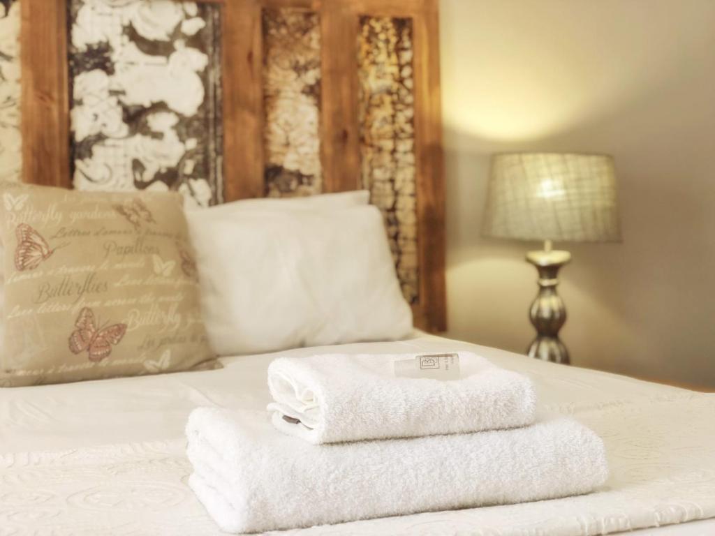 Una cama con dos toallas encima. en Louvre Guesthouse, en Bothaville