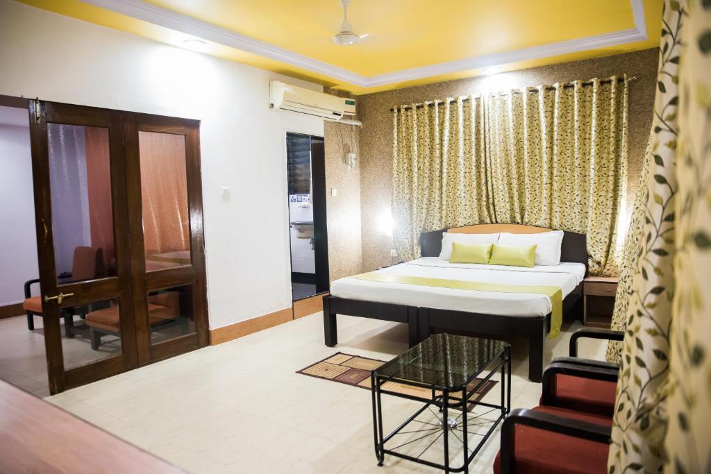 una camera con un letto e una sedia di Hotel Tanish a Madgaon