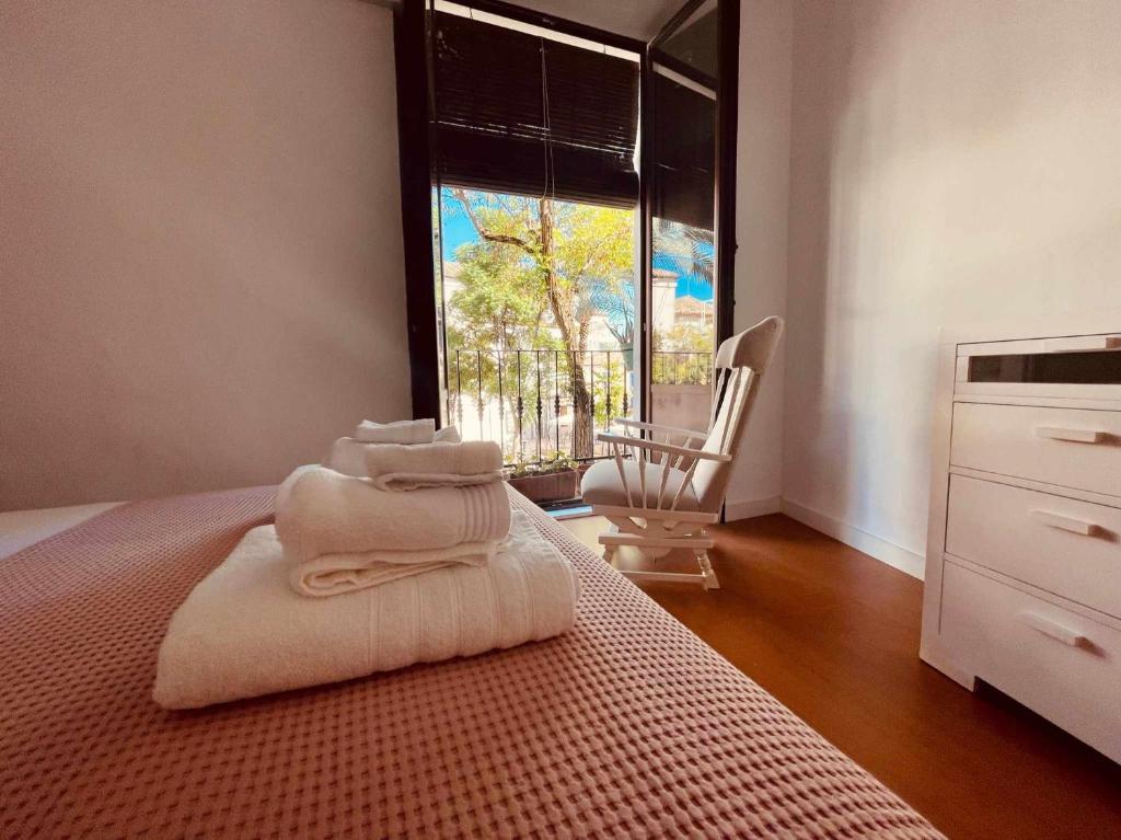 een kamer met een bed met een stapel handdoeken erop bij Precioso apartamento en Plaza de las Cañas in Córdoba