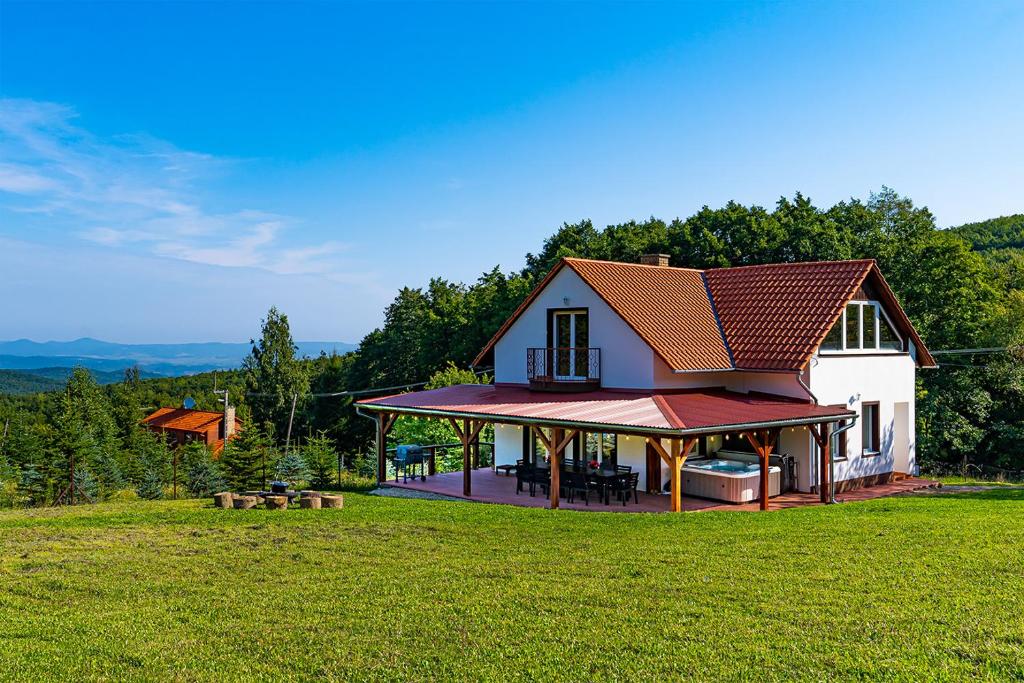 uma casa com um gazebo num campo verde em Villa Szalamandra - a Tisztás em Matraalmas