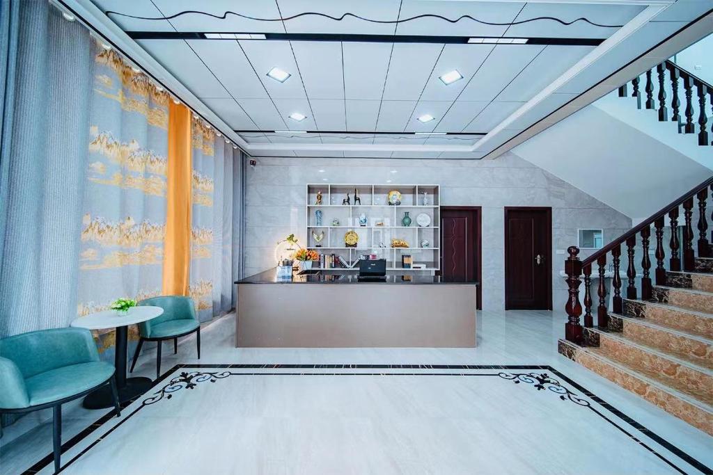 - un hall avec une réception et des chaises bleues dans l'établissement Longhushan Hanxiangju Homestay, à Yingtan