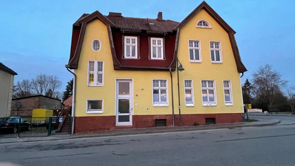 a yellow house on the side of a street at Alte Post - Erdgeschoß in Gützkow