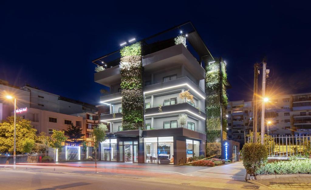a building with a lit up facade at night at Moncafe Boutique Hotel & SPA Tirana in Tirana