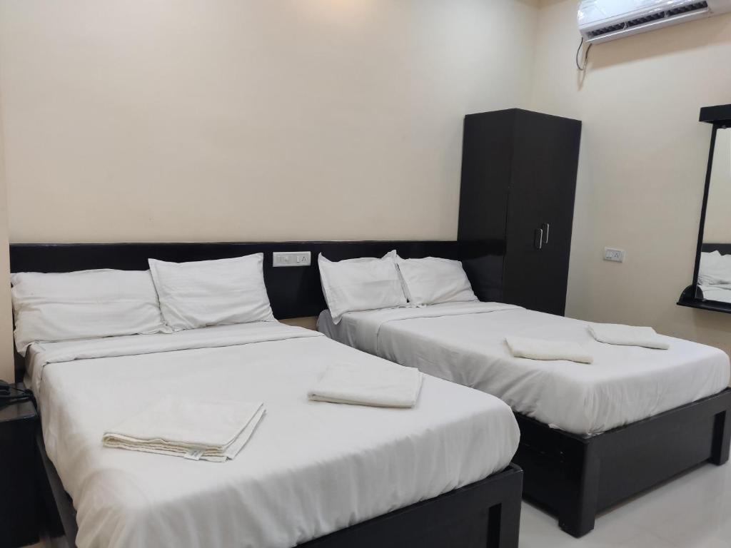 Postel nebo postele na pokoji v ubytování SRI VIGNESH RESIDENCY