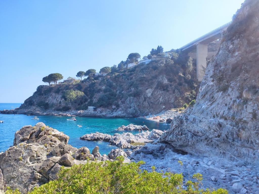 a bridge on a mountain next to a body of water at Appartamento Affaccio sul mare, Baia di Copanello in Copanello