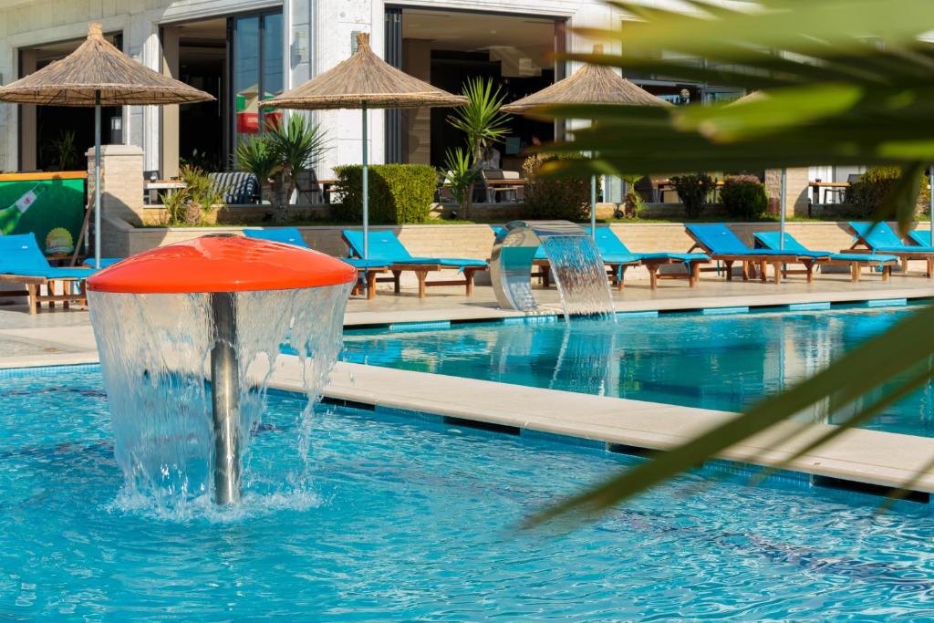 a fountain in the middle of a swimming pool at Kraal Hotel Vlore in Vlorë