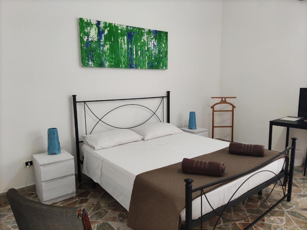 1 dormitorio con 1 cama y una pintura en la pared en Stellium, en Palermo