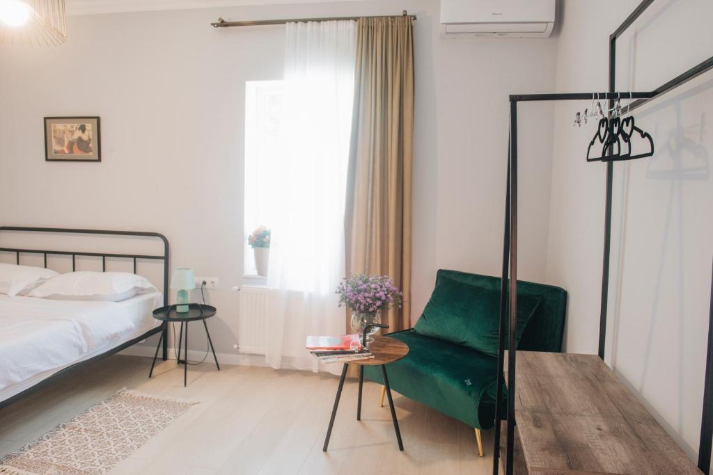 1 dormitorio con sofá verde y cama en Homey en Tiflis