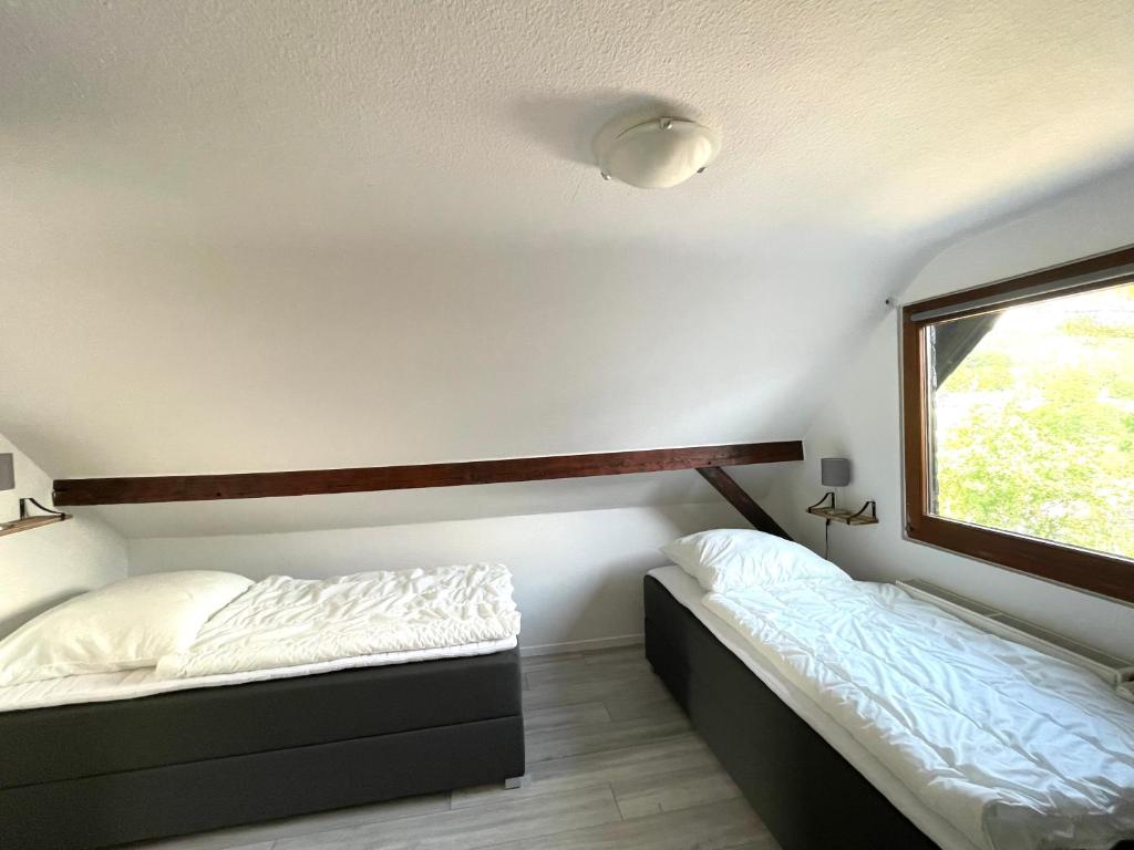 two beds in a room with a window at Ferienhaus Sonnendeck in Simmerath